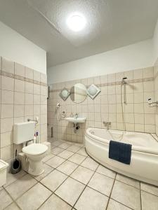 a bathroom with a tub and a toilet and a sink at Holiday Apartment Adenau in Adenau