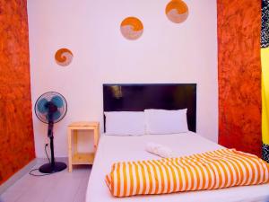 ein Schlafzimmer mit einem Bett mit einer schwarzen und gelben gestreiften Decke in der Unterkunft Dakar International House in Dakar