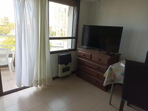 a television on a dresser in a room with a window at Departamento Plaza Moreno con balcón in La Plata