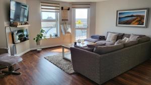 - un salon avec un canapé et une télévision dans l'établissement Sea Renity Apartment, à Newcastle
