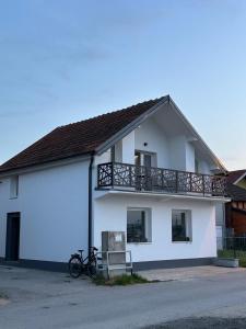 a white building with a balcony and two bikes at Košava in Golubac