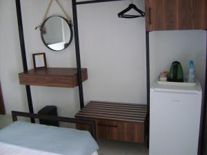 um quarto com uma cama, um espelho e um frigorífico em Pansion Thanos em Ouranoupoli