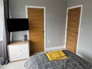 um quarto com uma cama com uma toalha amarela em New one bed 1st floor flat close to the beach em Southbourne