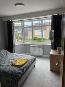 a bedroom with a bed and a large window at Great one bed 1st floor flat close to the beach in Southbourne