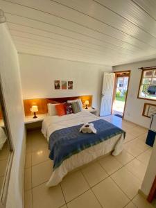 a bedroom with a large bed with a stuffed animal on it at Pousada Jardim de Búzios in Búzios