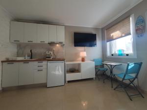 a kitchen with white cabinets and a table and chairs at Dave Apartment Nikiti, Seaview Terrace, near Harbor in Nikiti