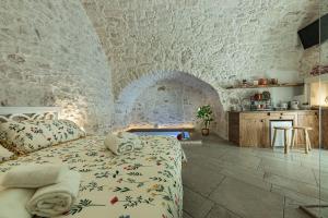 - une chambre avec un lit et un mur en pierre dans l'établissement Luxury Suite Of Ostuni, à Ostuni