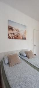 - 2 lits dans une chambre avec une photo sur le mur dans l'établissement Central Ana Apartment Novi Sad, à Novi Sad