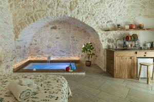 - une chambre avec une baignoire dans un mur en pierre dans l'établissement Luxury Suite Of Ostuni, à Ostuni