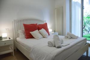 een slaapkamer met een bed met rode en witte kussens bij Jama Maison Garden in Napels