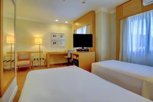 圣保罗Flat Nobile Congonhas的配有床、书桌和电视的酒店房间