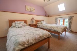 a bedroom with two beds and a window at Post House in Holsworthy