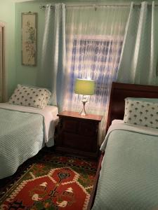 a bedroom with two beds and a lamp on a table at House next to the golf course in Plantation