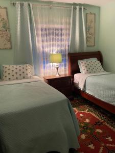 a bedroom with two beds and a lamp and a window at House next to the golf course in Plantation
