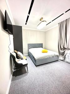 a bedroom with a bed and a chair at Muras Ordo Hotel in Bishkek