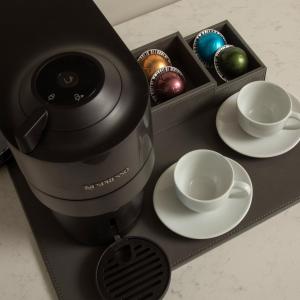 a black coffeemaker with a cup and plates and bowls at Stilwell Hotel in Carmel