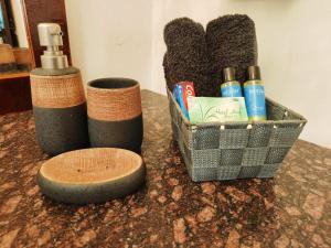 a bathroom counter with a basket of toothbrushes and toothpaste at Nada Brahma Patnem Beach in Patnem