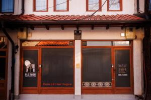 a store front with glass doors with a sign on it at Xhubleta Room - Old Bazaar in Peje