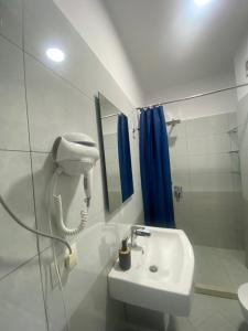 a bathroom with a sink and a phone on the wall at guesthouse apartments in Tirana