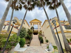 una casa con palmeras delante en Beachside home in Marbella for couples, en Marbella