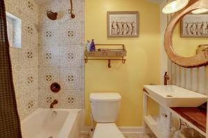 a bathroom with a tub and a toilet and a sink at 4-Season Gold Coast Cottage, 2 Mi to Winter Sports in Muskegon