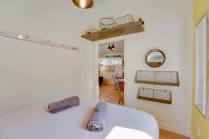 1 dormitorio con cama blanca y pasillo en 4-Season Gold Coast Cottage, 2 Mi to Winter Sports, en Muskegon
