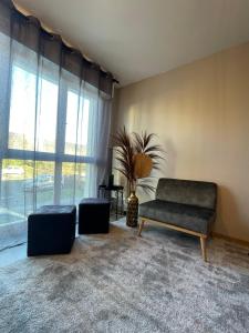 uma sala de estar com um sofá e uma grande janela em Au calme de la Gaité em Saint-Jacques-de-la-Lande