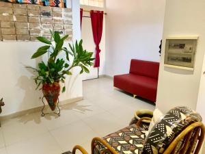 a living room with a red couch and a plant at Studio liberté 2 in Dakar