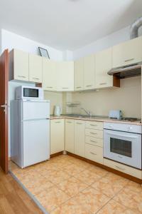 a kitchen with white appliances and white cabinets at Todorka Apartments in Bansko in Bansko