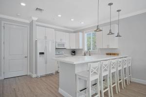 a kitchen with white cabinets and a white refrigerator at Isla Key Lime - Waterfront Boutique Resort, Htd Pool, Dock, Walkable in Islamorada