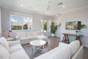 a white living room with white couches and a table at Isla Key Lychee - Waterfront Boutique Resort, Island Paradise, Prime Location in Islamorada