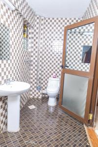 a bathroom with a toilet and a sink and a shower at Paleo Hotel and Spa in Thika