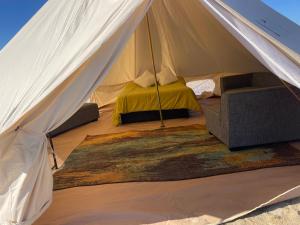 a tent with a bed and a couch in it at New Yurt City in Lake Los Angeles
