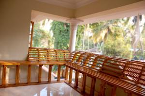 a balcony with a large window and wooden benches at Venice Castle in Alleppey
