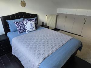 1 dormitorio con 1 cama grande con sábanas y almohadas azules en B&B des Ambres, en Denderleeuw