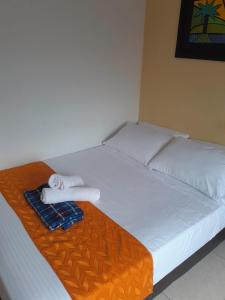 1 cama con 2 almohadas y toallas en Hotel Najjez en Villavicencio