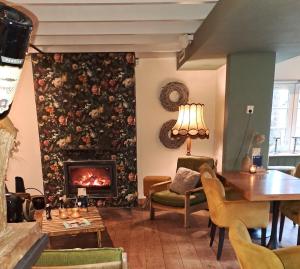 a living room with a fireplace and a table at Herberg de Loohoeve in Schoonloo