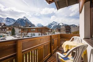 a balcony with a table and chairs and mountains at Haus Kirchmaier in Pertisau