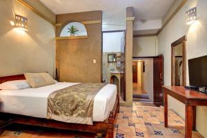 Dormitorio con cama, escritorio y TV en Hotel Cielo, en Playa del Carmen
