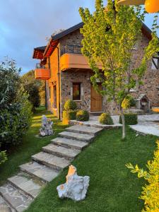 a house with a garden with stone steps in front of it at Shtepia Tradites Gjinar in Elbasan