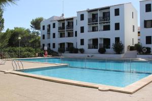 une grande piscine en face d'un bâtiment dans l'établissement Menorca Arenal d'en Castell, à Arenal d'en Castell