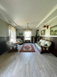 Brīvdienu māja Dinary في Dagda: غرفة معيشة كبيرة مع أريكة وسجادة
