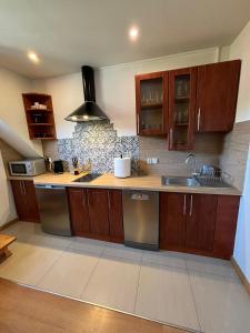 a kitchen with wooden cabinets and a sink at Apartamenty Borysek De Lux in Białka Tatrzańska