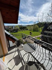 a balcony with chairs and a table and a view of a field at Apartamenty Borysek De Lux in Białka Tatrzanska