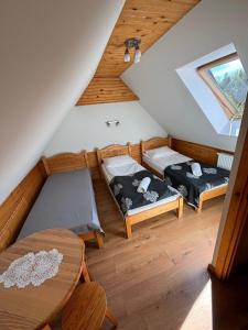 a attic room with two beds and a table at Apartamenty Borysek De Lux in Białka Tatrzanska +130 photos