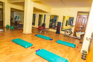 a gym with a bunch of pilates equipment at Paleo Hotel and Spa in Thika
