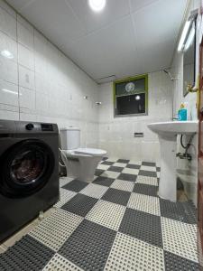 a bathroom with a toilet and a washing machine at Travelers Friend Capsule 5 min walking Sharaf DG metro station in Dubai