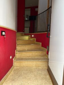 una escalera en un edificio con una pared roja en conny, en Pachino