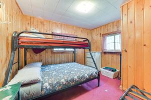 Etagenbett in einem Zimmer mit Holzwänden in der Unterkunft Roscommon Cabin Less Than Half-Mi to Higgins Lake! in Roscommon