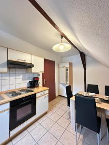 a kitchen with a stove and a table with chairs at Holiday Apartment Adenau in Adenau